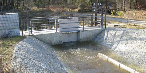 im Vordergrund das neue Überleiterbauwerk, Wasser steht davor an, im Hintergrund das Tranitzfließ