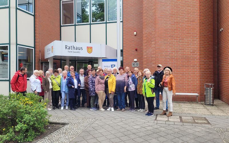 Die Gruppe Seniorinnen und Senioren steht aufgestellt vor dem Besuchereingang des Rathauses in der Lindenstraße.
