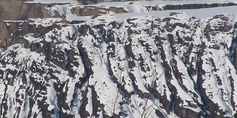 Der Schnee verziert die Rippen der Uferböschung.