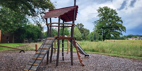 Ein Kletterturm mit 4 verschiedenen Aufstigen (Netz, Schräge, 2 Leitern) und einer Rutsch auf der rechten Seite. 