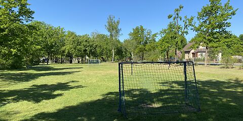 Blick von hinter einem Tor auf den Bolzplatz aus.