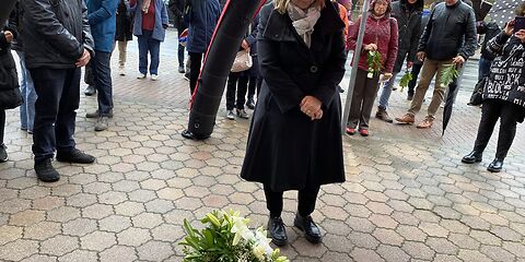 Die Bürgermeisterin steht vor den Stolpersteinen mit gesenktem Blick und verschränkten Händen.