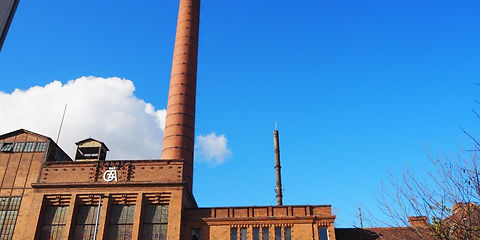Heizkraftwerk Gustav Avellis, Straßenansicht, rötlich-btauner Ziegelbau mit einem Industrieschornstein
