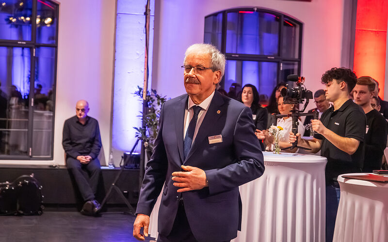 Landrat Harald Altekrüger auf dem Weg zur Bühne. Er trägt einen dunklen Anzug, ein weißes Hemd und eine dunkle Krawatte.