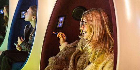 Drei Sessel in Form eines halben Eis, in denen jeweils ein Mädchen sitzt.