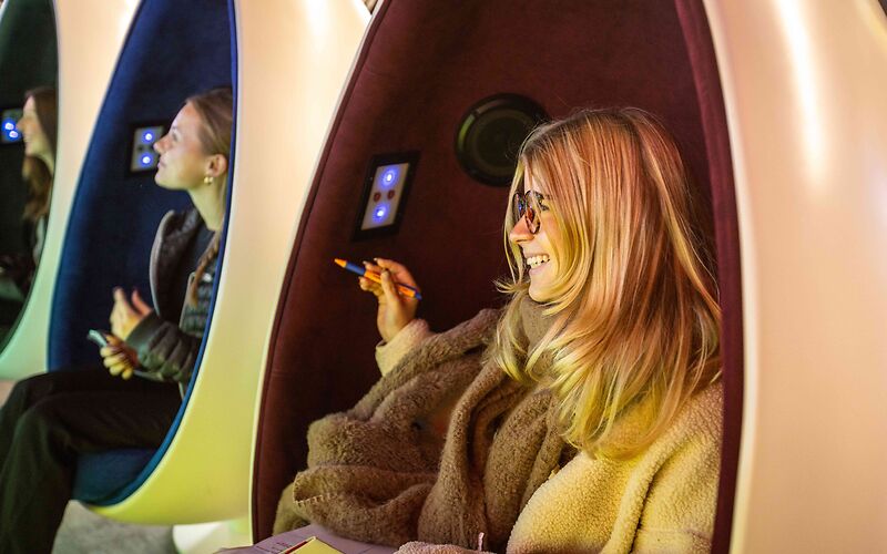 Drei Sessel in Form eines halben Eis, in denen jeweils ein Mädchen sitzt.