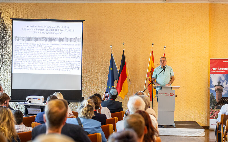 Herr Frank Heiber hält anlässlich der Verlegung der Stolpersteine eine Rede im Saal der Grundschule Mitte.