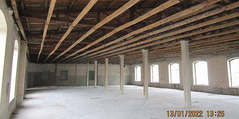 Blick in die leere Fabriketage. Alle nicht tragenden Wände sind zurück gebaut. Die Unterhangdecke ist abgebrochen. Man sieht  die Dachbalken und die Schalung.