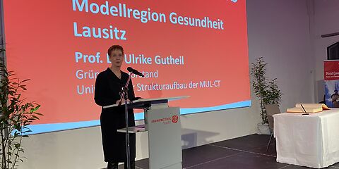 Frau Prof. Dr. Gutheil, Vertreterin der Modellregion Gesundheit Lausitz, hält auf der Bühnen einen Vortrag.