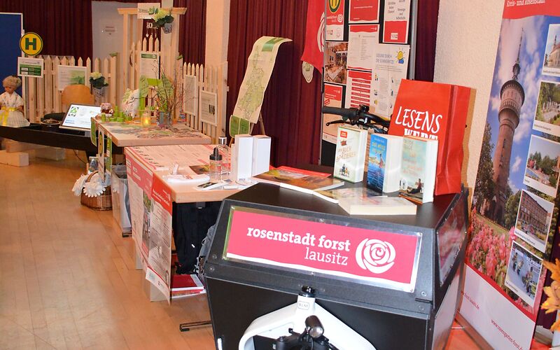 Der Stand der Stadtverwaltung Forst (Lausitz) mit verschiedenen Infomaterialien und einem Aufsteller mit Fotos aus dem Stadtgebiet (Wasserturm, Textilmuseum, Radrennbahn, Rosengarten).