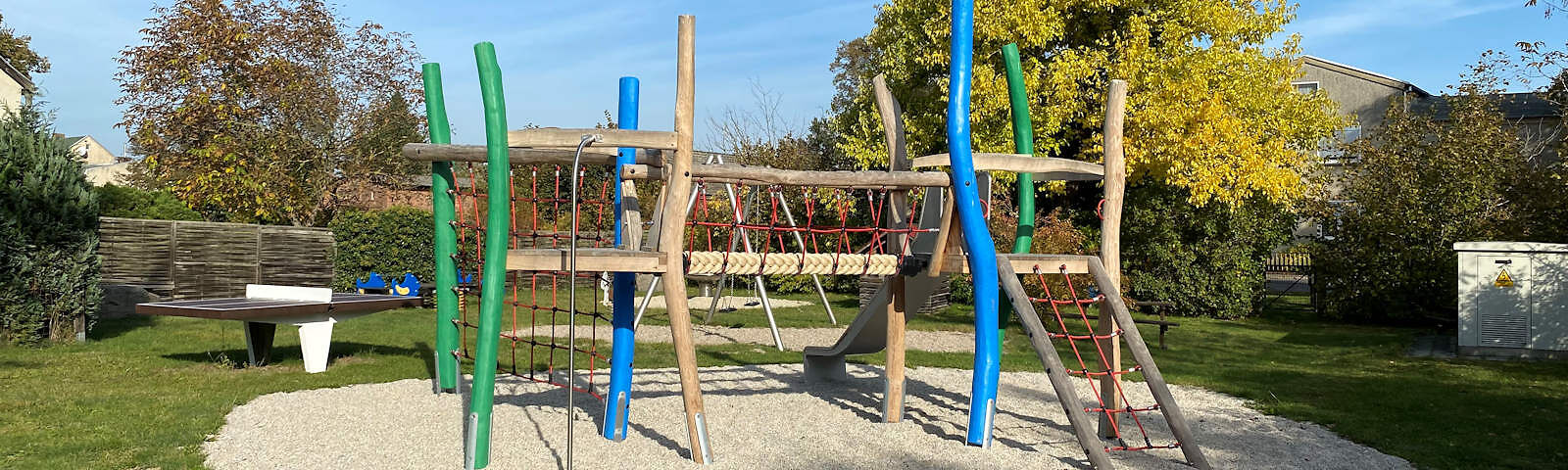 Klettergerüst aus Holz mit einem Aufstieg über ein Seilnetz, mehreren Seilnetzen im oberen Bereich an den Seiten und einem großen Seilnetz am linken Ende